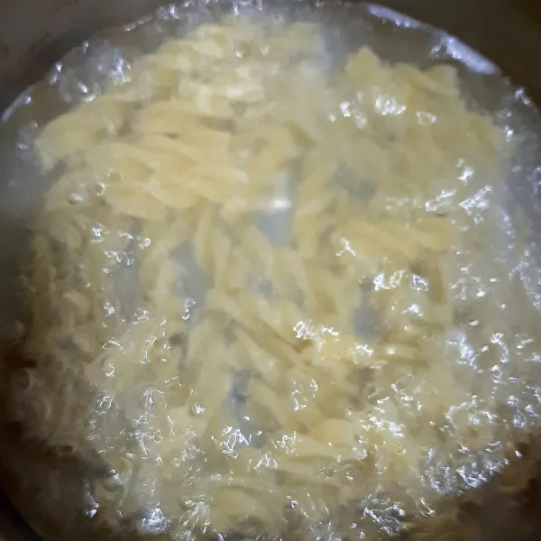 Rebus fusilli hingga al dente. Lalu angkat dan tiriskan.