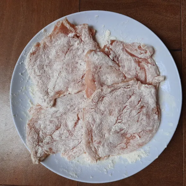 Lumuri seluruh permukaan ayam dengan tepung terigu.