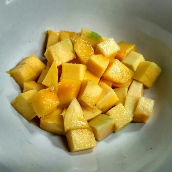 Kupas mangga dan potong kotak kecil.