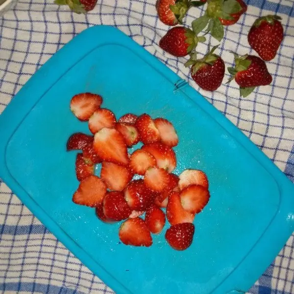 Buang tangkai buah strawbery. Cuci dan belah menjadi 2 bagian.