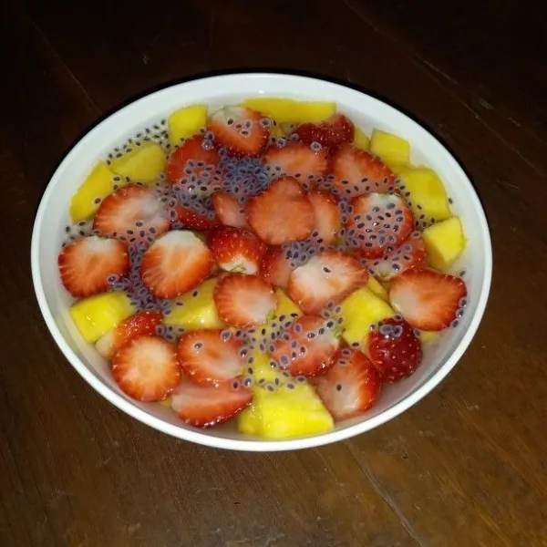 Tambahkan potongan buah strawbery, biji selasih dan es batu secukupnya.
