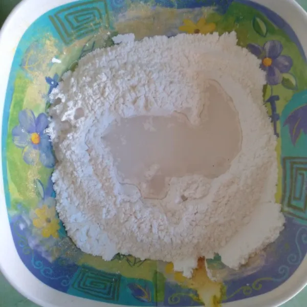 Dalam mangkuk, masukkan tepung beras dan tapioka. Masukkan juga gula, garam dan air sedikit demi sedikit sambil diuleni.