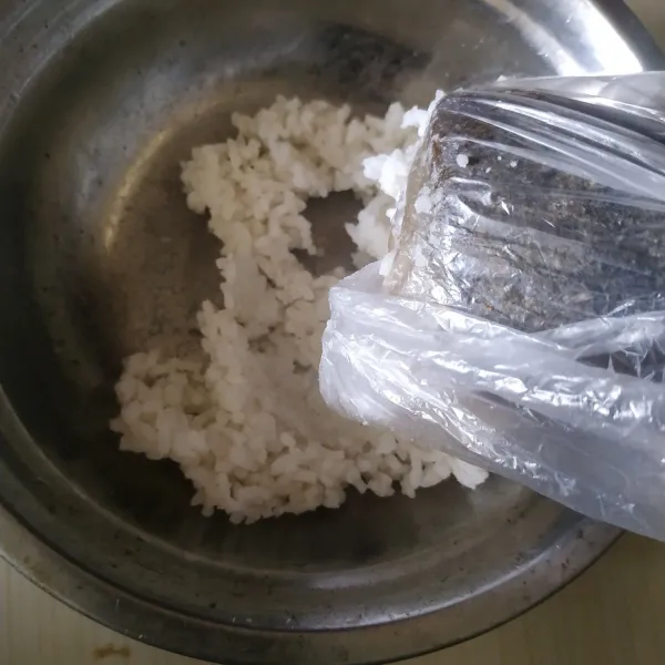 Haluskan nasi menggunakan ulekan.