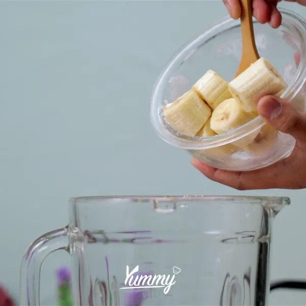 Siapkan blender lalu masukkan pisang yang telah diiris ke dalamnya.