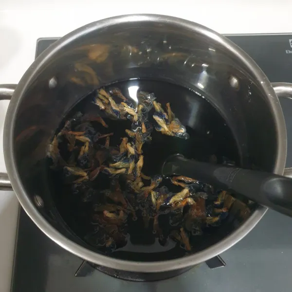 Rebus air dan bunga telang sampai air rebusan berwarna biru pekat, angkat saring dan takar sebanyak 750 ml, biarkan dingin.