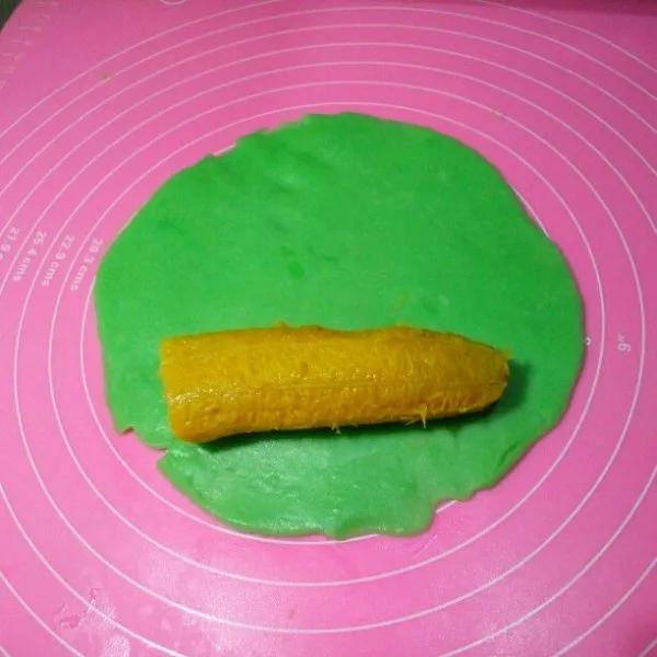 Bagi adonan jadi 6 bagian sama berat. Pipihkan, jangan lupa oles tangan dan alas kue dengan minyak goreng supaya tidak lengket. Taruh pisang diatasnya, lalu gulung.