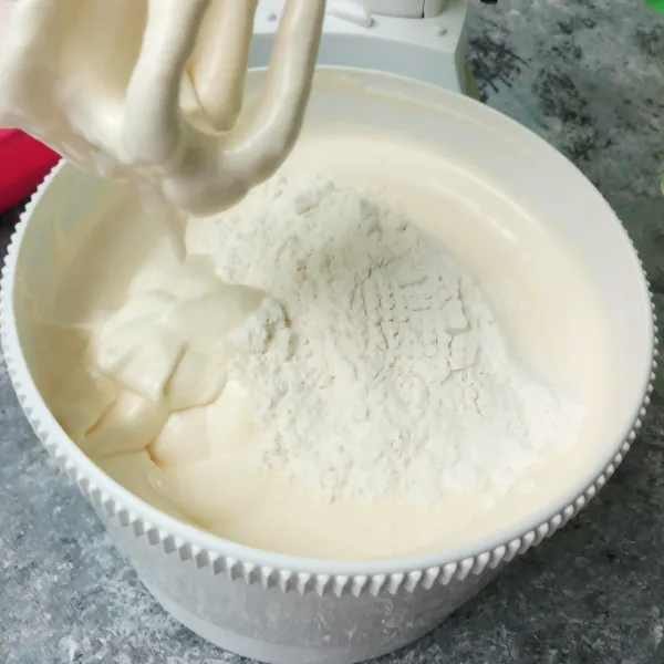 Lalu masukkan terigu dan vanili secara bertahap sambil diayak, mixer dengan speed rendah