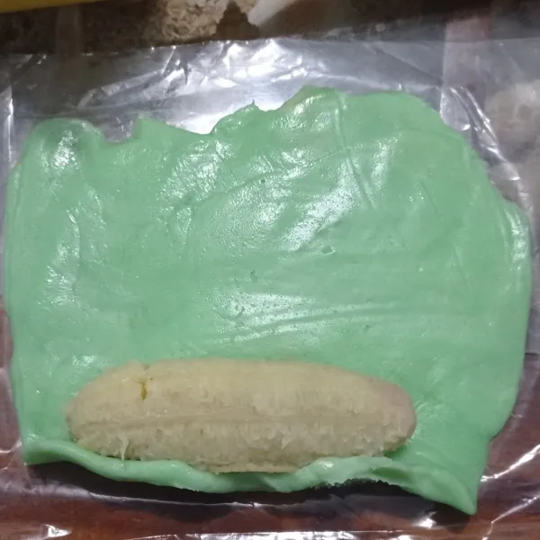 Ambil plastik poles dengan sedikit minyak goreng  lalu gilas bahan kulit ,letakan pisang lalu gulung kemudian bungkus dengan plastik, kukus selama 10 menit