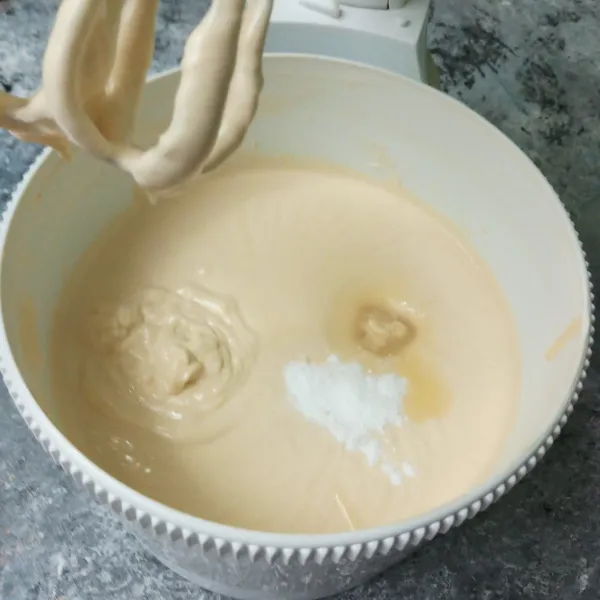 Masukkan kental manis dan baking powder, mixer rata