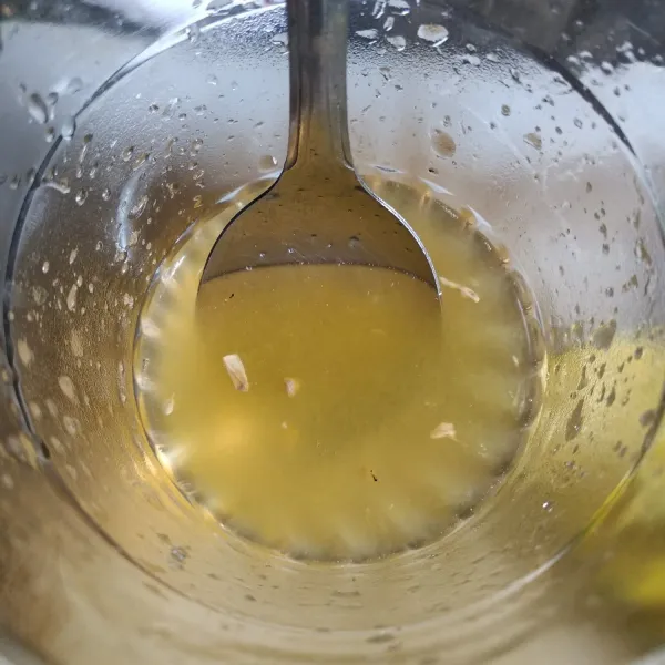 Peras jeruk kunci ke dalam gelas berisi air larutan gula.