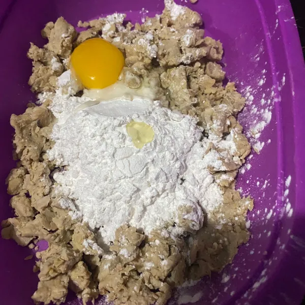 Setelah itu letakkan tempe di wadah dan haluskan. Masukkan tepung terigu, telur, tepung tapioka, bawang putih halus, dan merica bubuk.