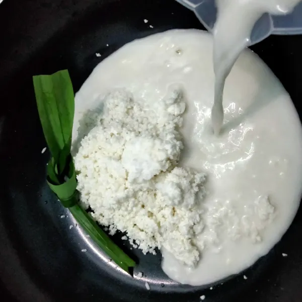 Masukkan beras yang sudah di blender ke dalam teflon, lalu masukan daun pandan, garam dan santan