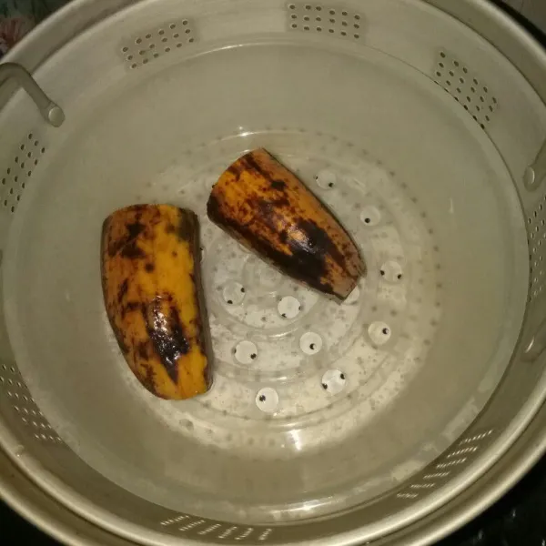 Kukus pisang bersama kulitnya sampai matang, angkat