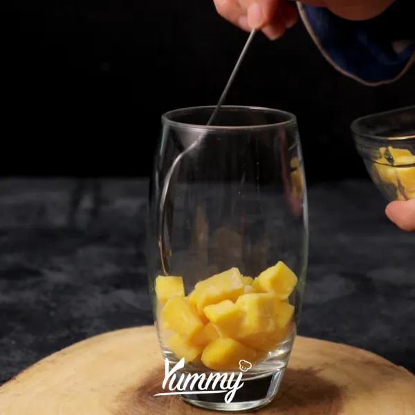 Siapkan gelas saji, masukkan tape singkong ke dalamnya.