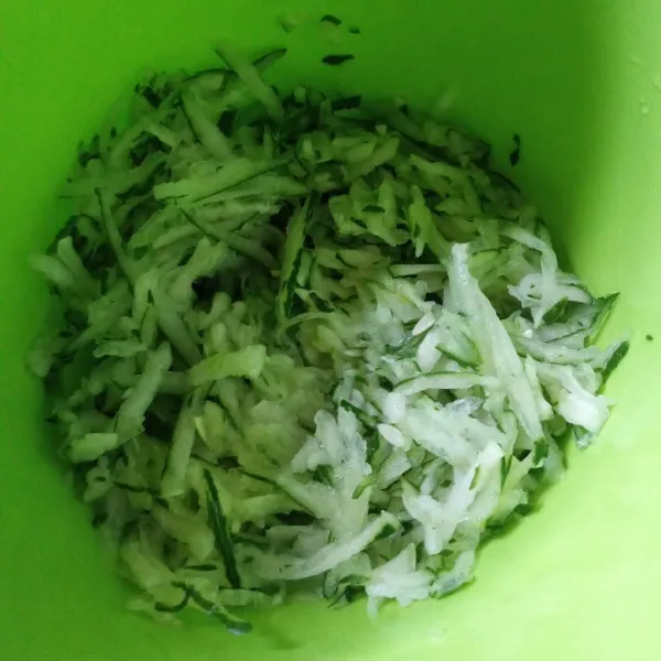 Serut panjang daging timun dan pindahkan ke wadah.