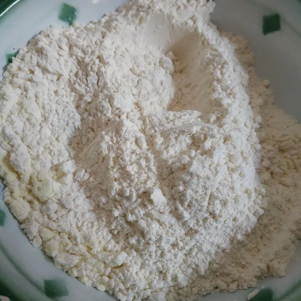 Campur jadi satu tepung terigu, susu bubuk, vanili, baking powder, dan soda kue. Aduk rata dan sisihkan.