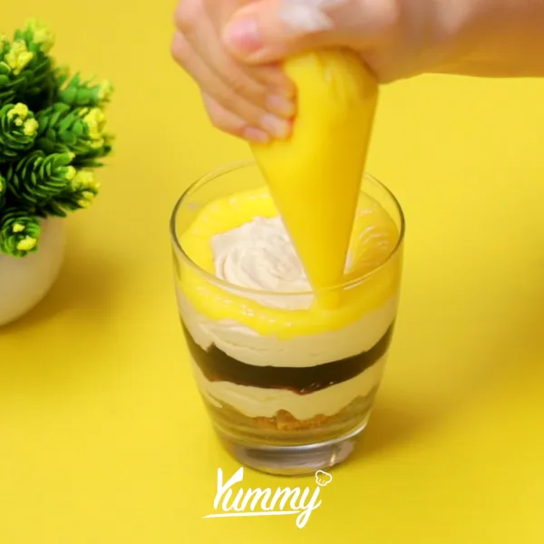 Beri lapisan krim keju lagi, tambahkan lemon curd diatasnya dan lapisi dengan adonan krim keju kembali, taburi dengan kulit lemon, sajikan.