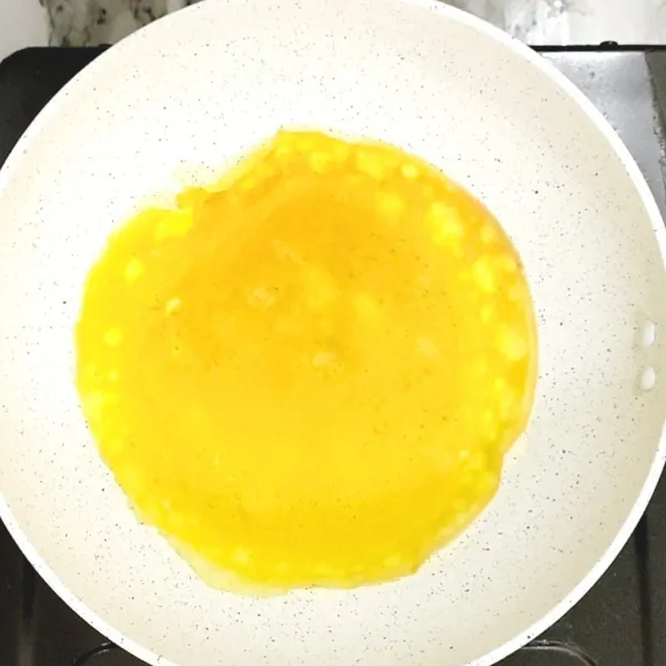 Panaskan wajan. Tuang adonan telur melebar di atas permukaan wajan. Tunggu sampai matang, lalu angkat.