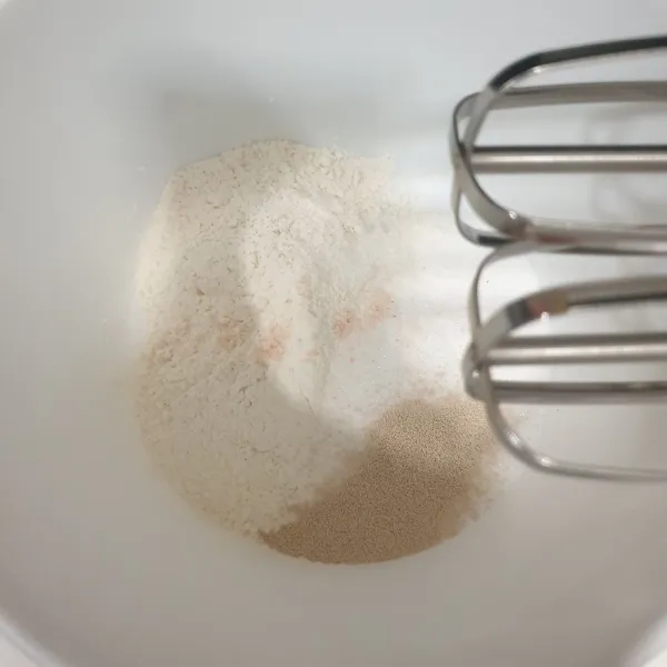 Campurkan tepung terigu, gula pasir, ragi instan, dan garam halus, Mixer perlahan sampai tercampur rata