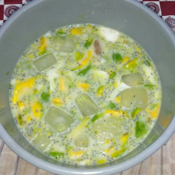 Masukan susu kental manis, air gula dan es batu aduk rata.