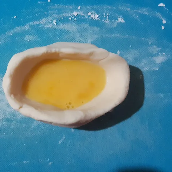 Ambil adonan secukupnya lalu bulatkan & beri lubang di tengahnya. Beri isian dengan telur.