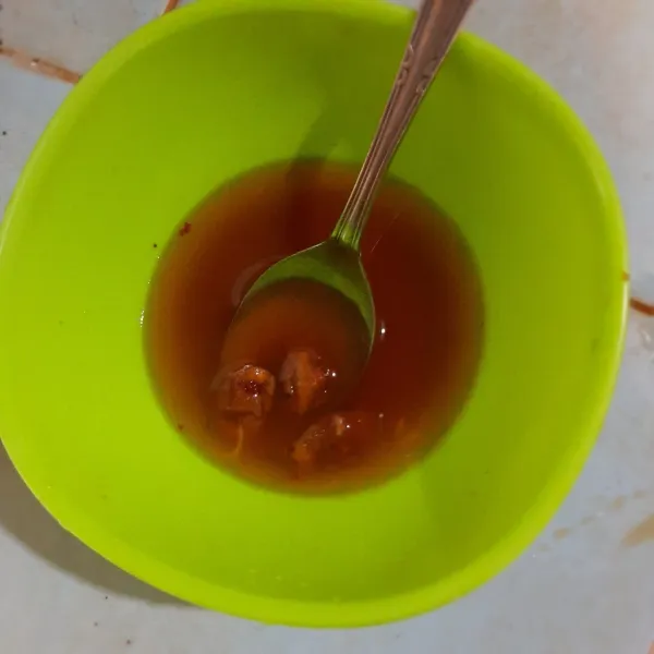 Campur gula merah dan asam jawa dengan air panas, larutkan.