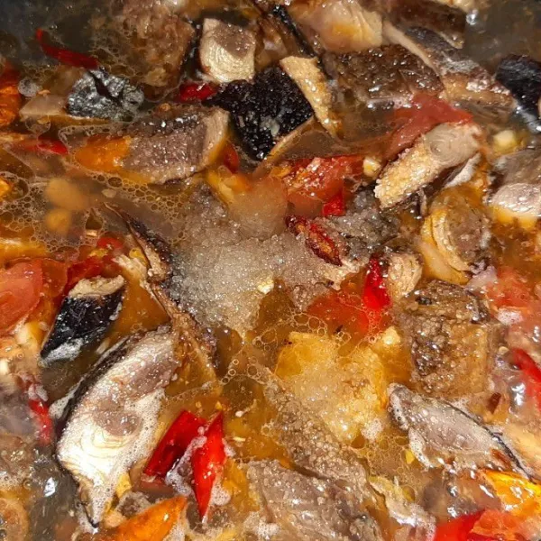 Beri sedikit air panas, masak ikan hingga bumbu meresap. Lalu koreksi rasa