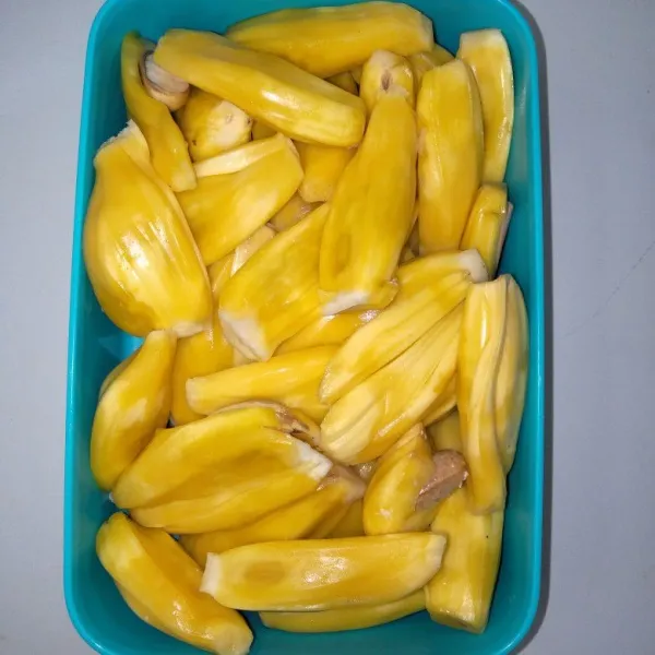 Pisahkan nangka dari kulit juga bijinya.