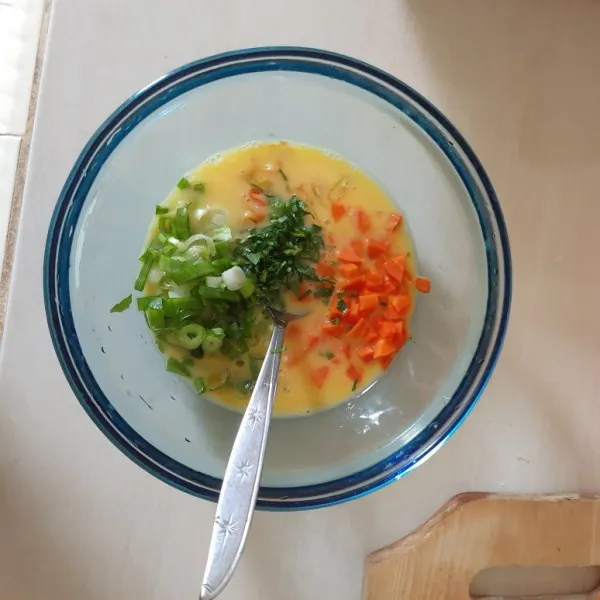 Selanjutnya kocok telur dan beri irisan bawang daun, wortel, seledri. Aduk rata.