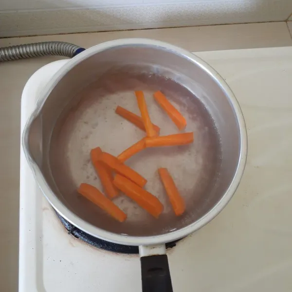 Pertama, rebus wortel sebentar. Lalu tiriskan dan potong dadu.