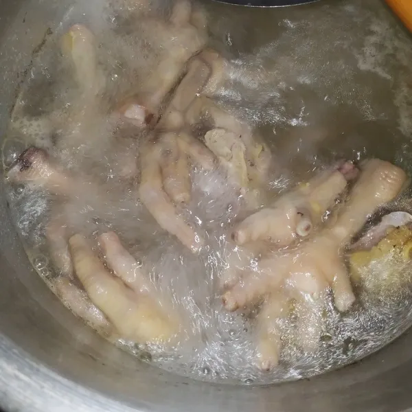 Cuci bersih lalu rebus ceker ayam hingga empuk.