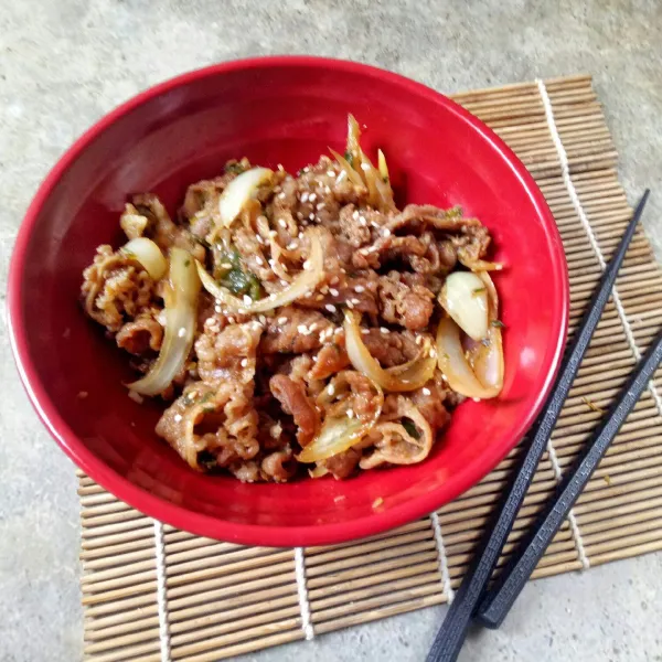 Siapkan nasi di mangkuk lalu beri gyudon cabai ijo, taburi dengan wijen