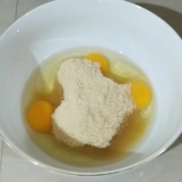 Dalam sebuah wadah, kocok telur, gula pasir, dan vanili cair. Kocok hingga gula pasir larut.