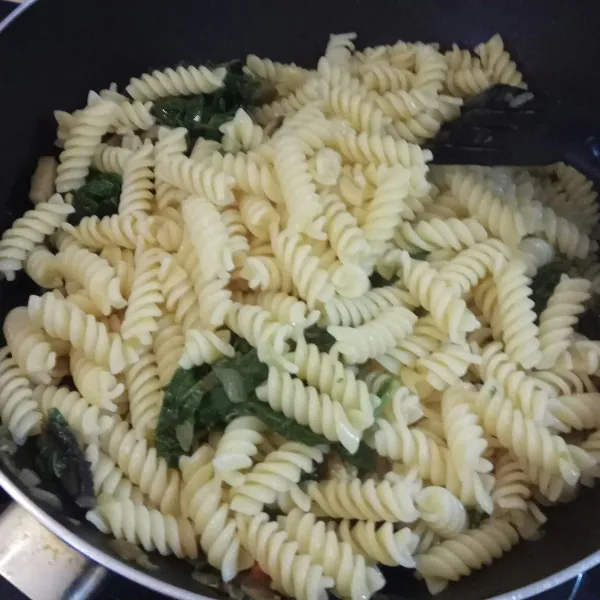 Masukkan fusilli yang sudah direbus, kemudian seasoning dengan garam dan lada. Tambahkan 5 sdm air rebusan pasta.