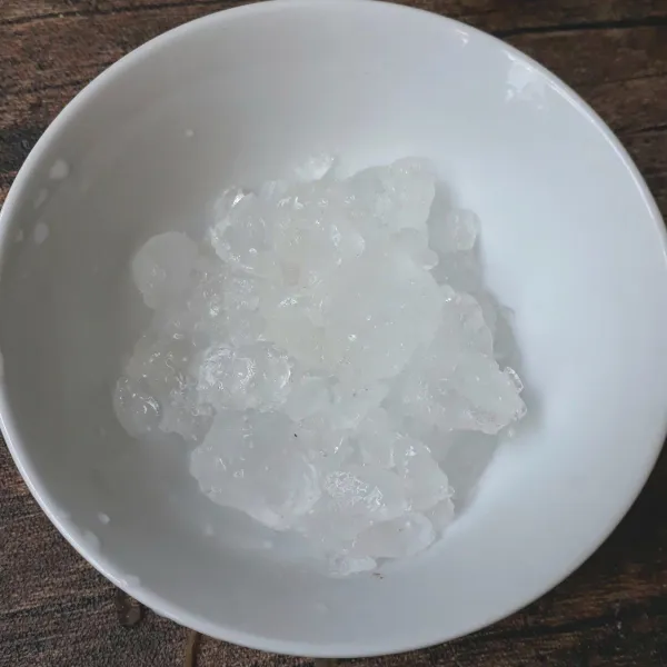 Sendokkan es batu yang sudah dihancurkan ke mangkuk.