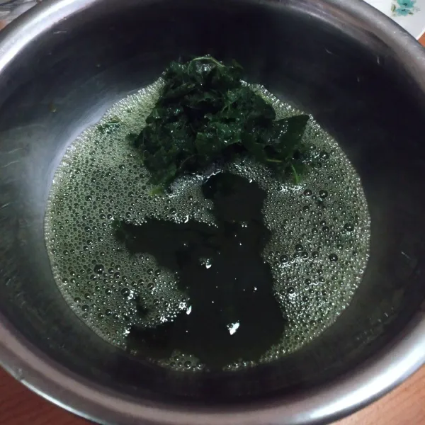 Masukkan daun cao dan 1 gelas air ke dalam wadah (masukkan air secara bertahap untuk memudahkan proses memeras). Peras-peras sampai air berubah hijau kental.