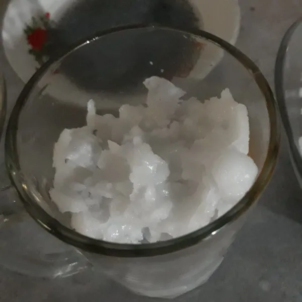 Siapkan gelas saji, lalu masukan es batu dan kelapa kopyor beserta airnya.
