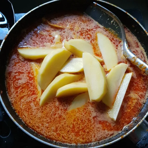 Setelah ayam matang masukkan santan encer. Tambahkan potongan kentang. Setelah kentang matang dan empuk masukkan santan kental. Aduk-aduk agar santan tidak pecah. Setelah mendidih matikan api.