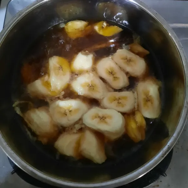Masukkan potongan pisang. Masak hingga pisang matang.