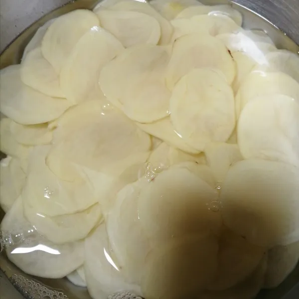 Cuci bersih kentang, lalu rendam dan tambahkan garam. Biarkan selama 30 menit.