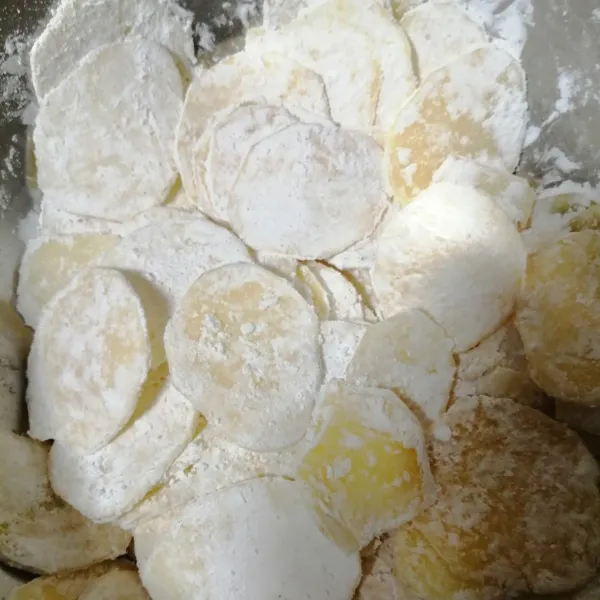 Tambahkan tepung maizena dan aduk sampai semua permukaan kentang tertutup tepung.