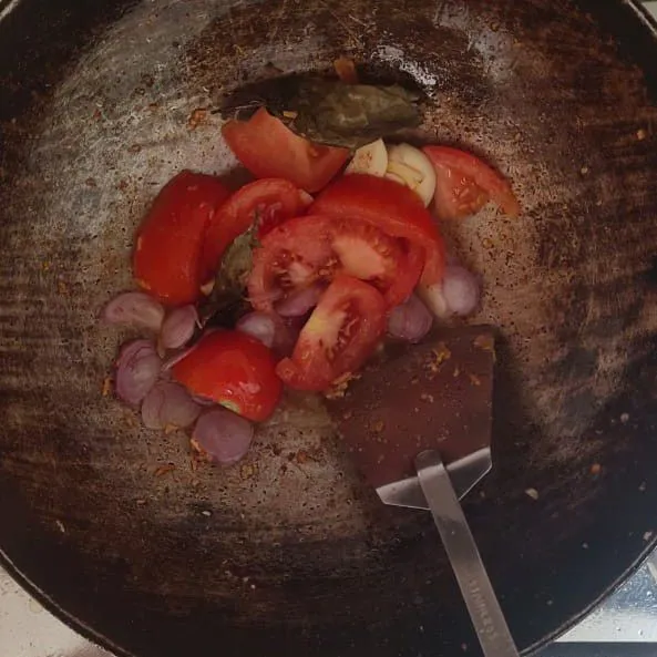 Panaskan sedikit minyak, lalu tumis bawang putih, bawang merah, tomat, dan daun salam hingga harum