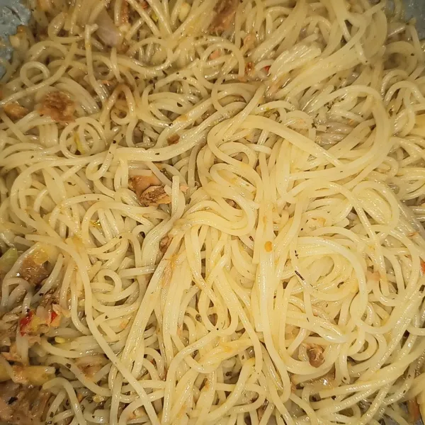 Masukkan spaghetti yang sudah direbus ke dalam tumisan, aduk sampai tercampur rata. Lalu masukkan daun basil, aduk lagi