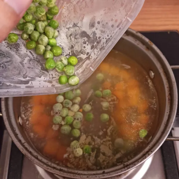 Masukkan bumbu kedalam rebusan wortel, tambahkan kacang polong.