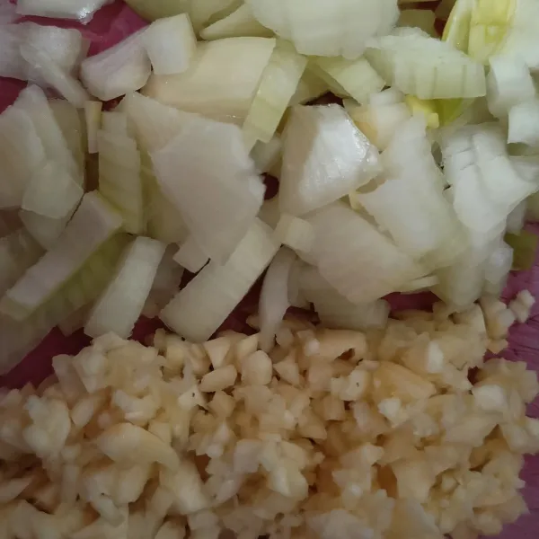 Sementara mi direbus, cincang halus bawang putih dan iris tipis bawang bombai