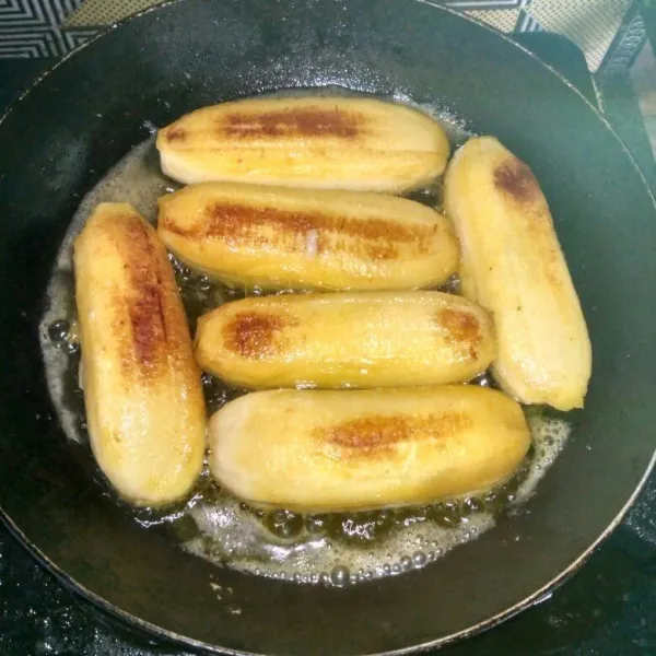 Panaskan minyak goreng dan mentega, lalu masukkan pisang dan goreng hingga agak kecoklatan.