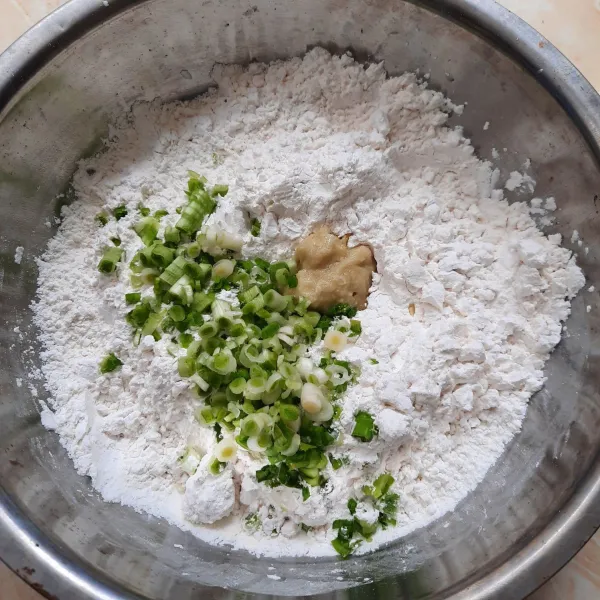 Campur tepung tapioka, tepung terigu, bawang putih yang sudah dihaluskan, dan daun pre yang sudah dirajang. Aduk rata