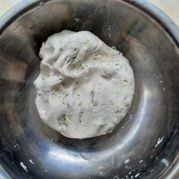 Masukkan air panas sedikit demi sedikit. Uleni hingga kalis