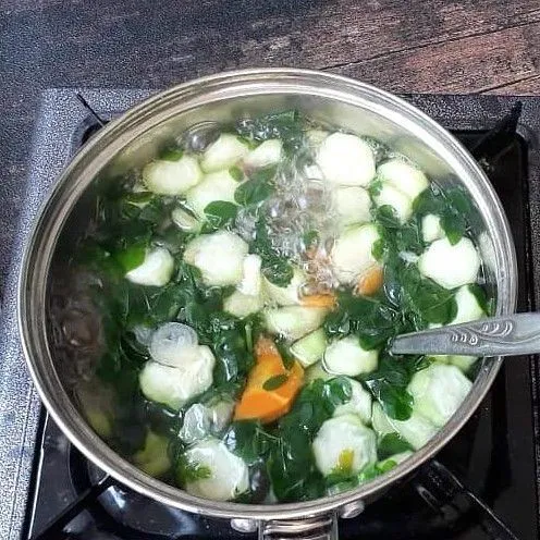 Masukkan wortel, setelah setengah matang masukkan oyong dan daun kelor, lalu aduk rata.