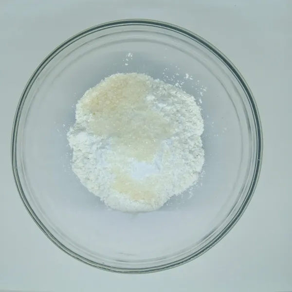 Campur tepung ketan putih dengan gula dalam wadah tahan panas.